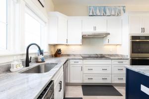 a white kitchen with white cabinets and a sink at New Build with Rooftop Deck & Panoramic Ocean Views in Kill Devil Hills +63 photos