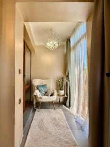 Una sala de estar con una silla y una lámpara de araña. en Sea Garden Escape - Byala, en Byala