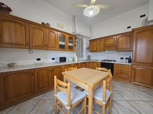 una cocina con armarios de madera y una mesa y sillas de madera. en Belvedere - By Ligooria, en Pietra Ligure
