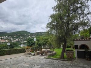 un parque con un árbol y un patio de piedra en Belvedere - By Ligooria, en Pietra Ligure