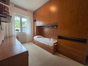 Un dormitorio con una cama y armarios de madera. en Belvedere - By Ligooria, en Pietra Ligure