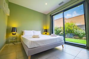a bedroom with a large bed and a large window at Villa Parenthèse - Élégance & Confort - clim in Perpignan +11 photos