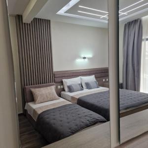a bedroom with two beds and a mirror at Mama Kitsa in Sarti