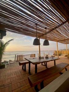 een picknicktafel met twee banken en uitzicht op de oceaan bij Casa Mar Puemape - beachfront in Puémape