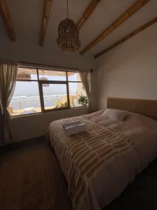 een slaapkamer met een bed met uitzicht op de oceaan bij Casa Mar Puemape - beachfront in Puémape