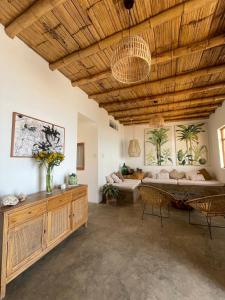 een woonkamer met een houten plafond en een bank bij Casa Mar Puemape - beachfront in Puémape