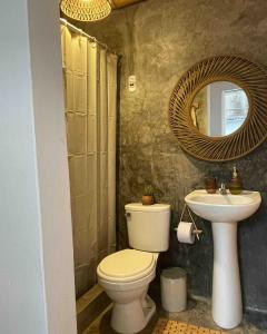 een badkamer met een toilet, een wastafel en een spiegel bij Casa Mar Puemape - beachfront in Puémape