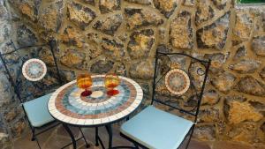 a table with two chairs and a stone wall at Apartment Tina in Hreljin