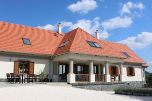 una imagen de una casa con techo naranja en Villa Tolnay Vendégház en Gyulakeszi