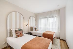una camera d'albergo con due letti e una finestra di Penthouse Praia de Olinda - Minho's Guest a Vila do Conde Altre 23 foto