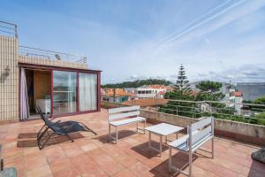 un patio con due sedie e un tavolo su un balcone di Penthouse Praia de Olinda - Minho's Guest a Vila do Conde