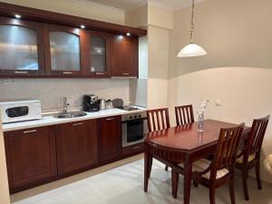 a kitchen with a wooden table with chairs and a sink at Downtown Bansko Luxury Resort in Bansko