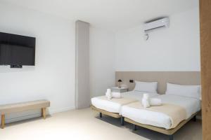 a bedroom with two beds and a flat screen tv at Apt new Mestalla | jacuzzi | billar | ping pong in Valencia