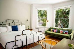a bedroom with a bed and a green couch at Miami River Inn by Renzzi in Miami +51 photos