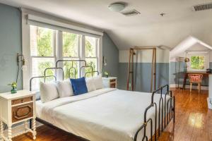 a bedroom with a large white bed with blue pillows at Miami River Inn by Renzzi in Miami +50 photos