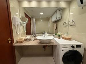 a bathroom with a sink and a washing machine at Downtown Bansko Luxury Resort in Bansko +16 photos
