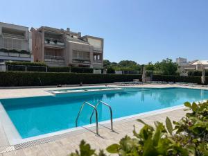 Una gran piscina azul frente a un edificio en Alloggio Soldatelli, en Fregene