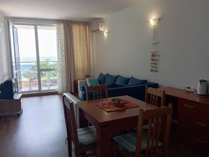 a living room with a table and a blue couch at Vilmar in Pomorie