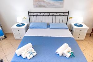 una camera da letto con un letto con asciugamani sopra di Marylife vacanze - appartamento a 20 mt dal mare a Trapani