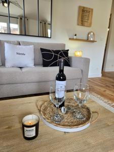 un tavolo con una bottiglia di vino e due bicchieri di le logis des roues a LʼIsle-sur-la-Sorgue