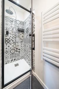 un bagno con box doccia e porta a vetri. di le logis des roues a LʼIsle-sur-la-Sorgue