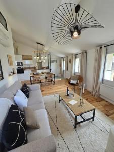 un soggiorno con un divano e un tavolo di le logis des roues a LʼIsle-sur-la-Sorgue