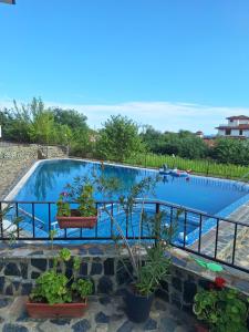 Una gran piscina con plantas y una valla. en Sea Garden Escape - Byala, en Byala