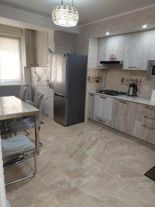 キシナウにあるApartaments Sandraのキッチン(ステンレス製の冷蔵庫、テーブル付) +1枚の写真