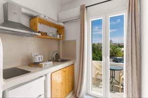 a kitchen with a view of a balcony at Athina Rooms - Lounge Apartments in Parikia