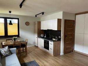 a living room with a kitchen and a table at Apartamenty Rubikon in Krakow