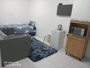 a room with a bed and a tv and a couch at Emlomo logde in Ermelo