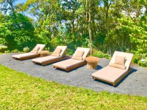 a group of chaise lounges and tables in a yard at Log Cabin - Monte Verde in Camanducaia +20 photos