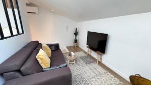 タランスにあるAppartement de charme avec accès piscineのソファと薄型テレビのあるリビングルーム