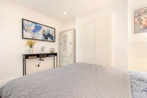 a white bedroom with a bed and a dresser at Grand Design Deluxe Suite by Buckingham Palace in London
