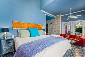 Un dormitorio con una cama grande y un sofá rojo. en Vibrant Location Artistic Home Downtown King Bed, en San Antonio