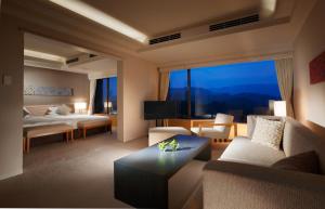 鳥羽市にある鳥羽国際ホテルのリビングルーム(ソファ、ベッド1台付)、大きな窓が備わります。