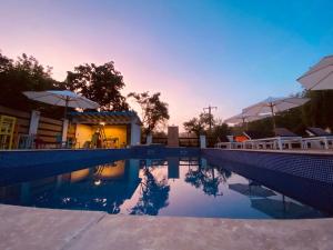 a pool with umbrellas next to a house at LA STORIA by Camping Mala in Eşelniţa