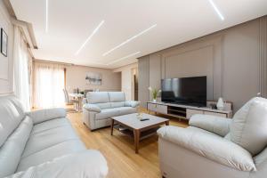 a living room with white furniture and a flat screen tv at Apartments Dream in Tivat +25 photos