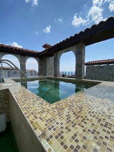 a swimming pool with a tile floor and a building at Marina Park OLIWIA in Sveti Vlas