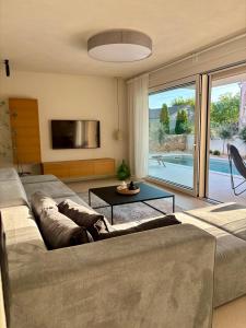 a living room with a couch and a large window at Brand New - Villa Olea Mare - Mediterranean Comfort and Style in Malinska