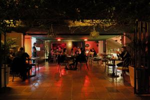 people sitting at tables in a restaurant at night at Casa En Llamas Hostal & Audio Bar - Armenia Eje cafetero in Armenia