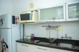 a kitchen with a sink and a microwave and a refrigerator at Entre Parque Moinhos e Country Club POA ZG6320 in Porto Alegre +8 photos