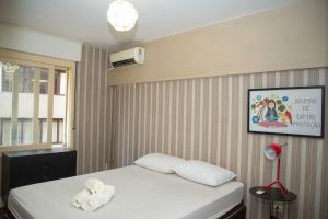 a bedroom with a bed with towels on it at Entre Parque Moinhos e Country Club POA ZG6320 in Porto Alegre