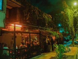 a group of people sitting at a restaurant at night at Casa En Llamas Hostal & Audio Bar - Armenia Eje cafetero in Armenia