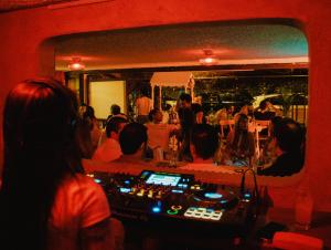 a group of people sitting at a bar in a room at Casa En Llamas Hostal & Audio Bar - Armenia Eje cafetero in Armenia