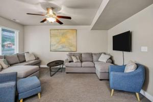 a living room with a couch and a ceiling fan at Bear Lake Escapes Garden City retreat in Garden City