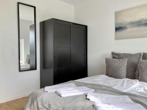a bedroom with a bed with white sheets and a mirror at Convenient Apartment for 2 in Aarhus