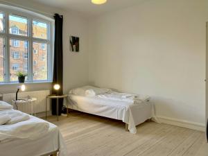 a bedroom with two beds and a large window at Convenient Apartment for 2 in Randers