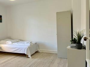 a white bedroom with a bed and a mirror at Convenient Apartment for 2 in Randers