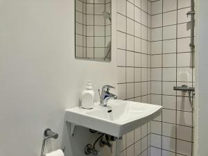 a white bathroom with a sink and a mirror at Convenient Apartment for 2 in Randers